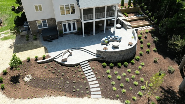 Completed curved paver patio, retaining walls, hot tub, and fire pit